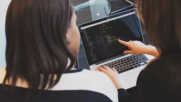 Women programmers viewing laptop screen