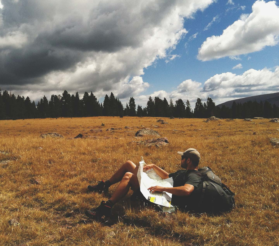 Hiker in a field reading a map